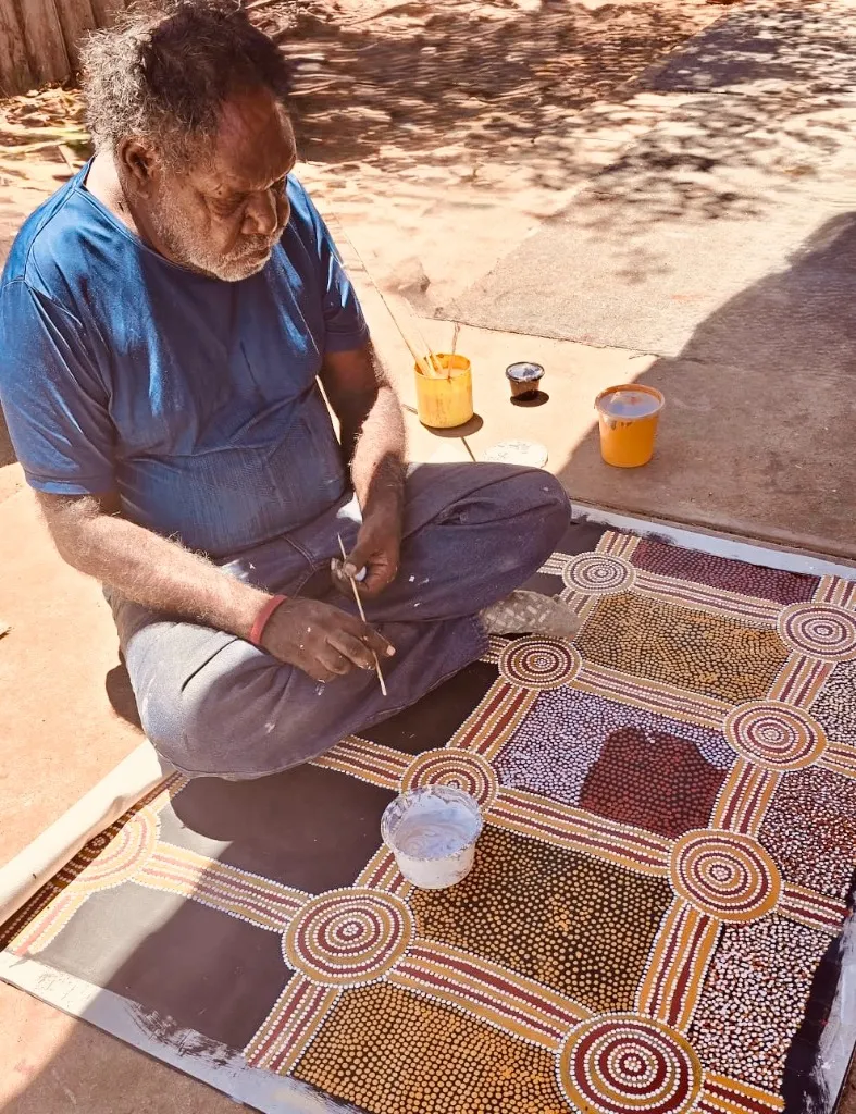 Indigenous participant painting dot art canvas