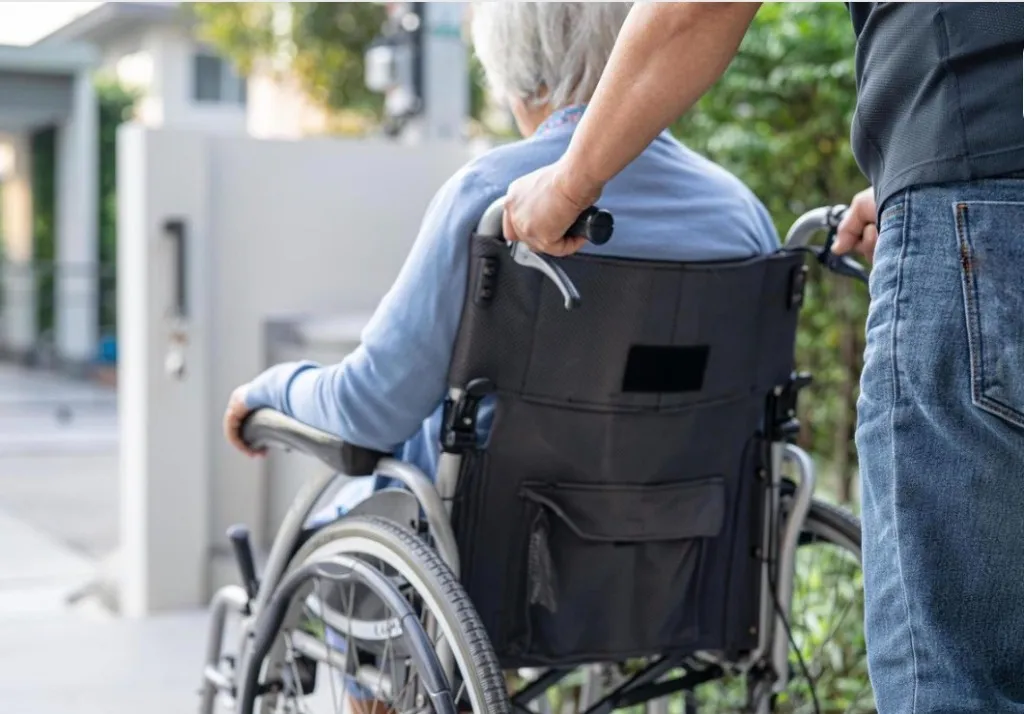 Support worker assisting participant in wheelchair
